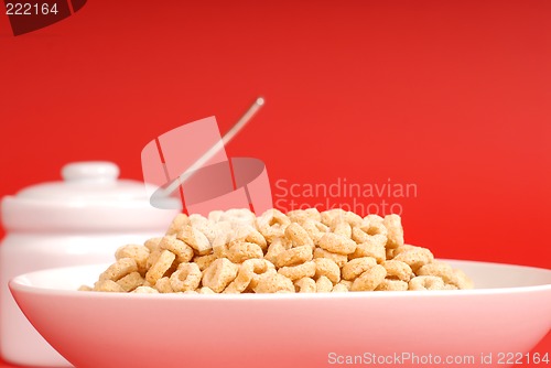 Image of A bowl of oat cereal with sugar bowl on red background