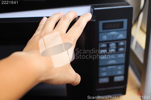 Image of Hand using microwave oven