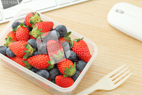 Image of Health lunch with strawberry and blueberry mix in office