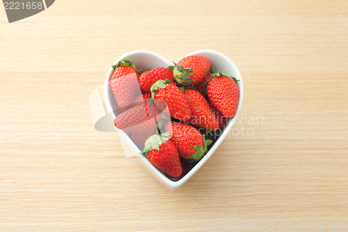 Image of Strawberry in heart shape bowl on wooden background