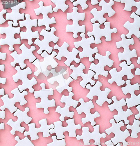 Image of White jigsaw puzzle on pink background