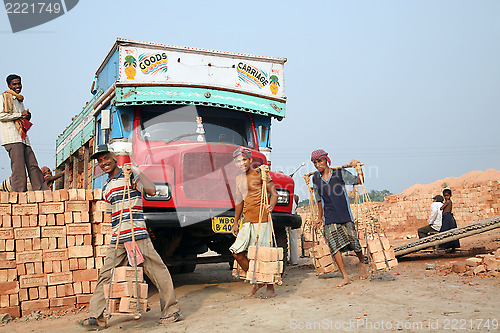 Image of Brick field workers carrying complete finish brick