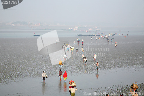 Image of During low tide the water in the river Malta falls so low that people walk to the other shore in Canning Town, India