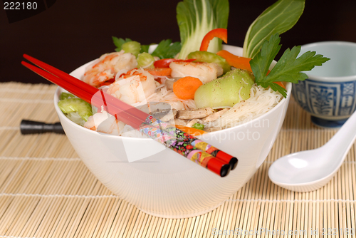Image of Udon noodles with vegetables and seafood with chopsticks