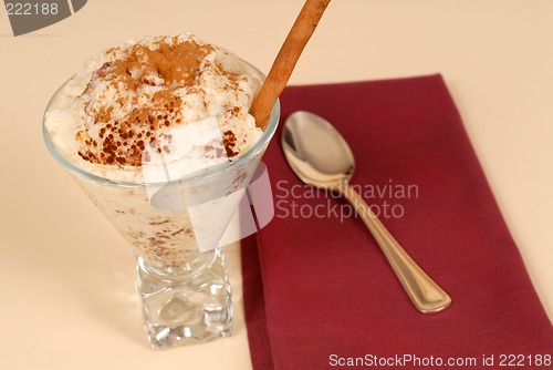 Image of Glass of rice pudding with cinnamon with a maroon napkin