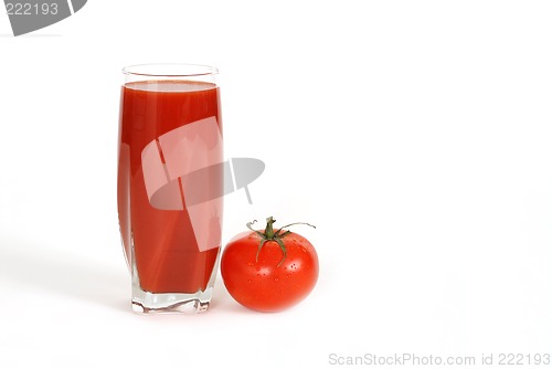 Image of Glass of tomato juice with tomato next to glass