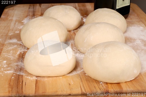 Image of Six balls of freshly made pizza dough on cutting board