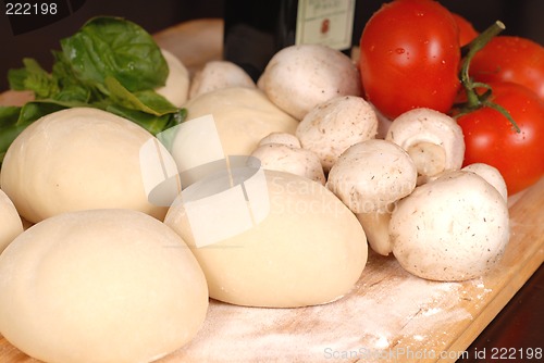 Image of The makings for a fresh homemade pizza on a cutting board