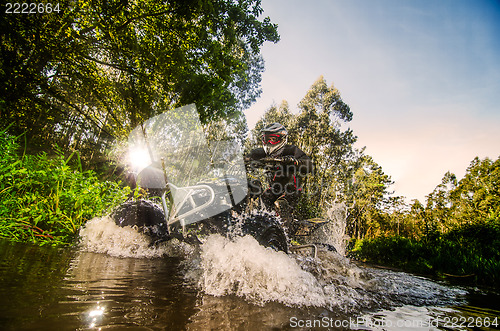 Image of Quad rider through water stream