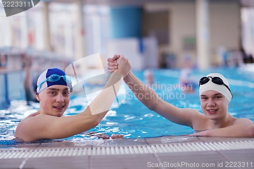 Image of happy teen group  at swimming pool