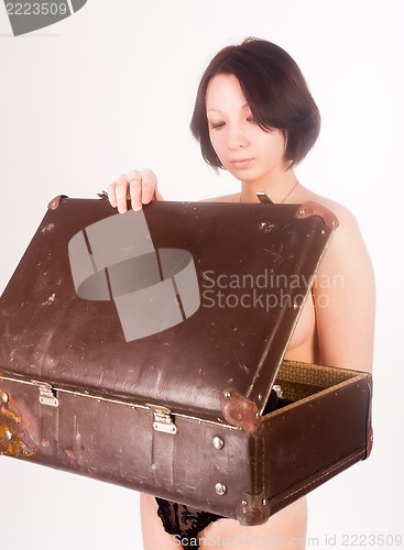 Image of sexy nude woman looking in open suitcase
