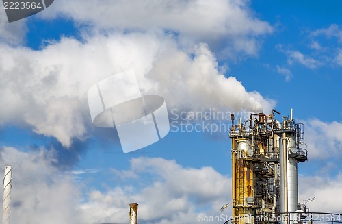 Image of industrial smoke from chimney on blue sky