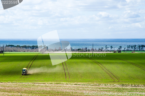 Image of Tractor farming in a green field