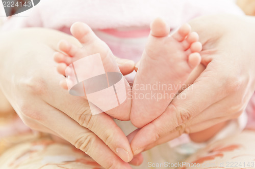 Image of Feet of newborn baby in mothers hands 