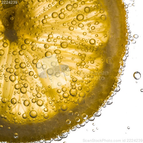 Image of close-up of lemon slice in clear water with bubbles