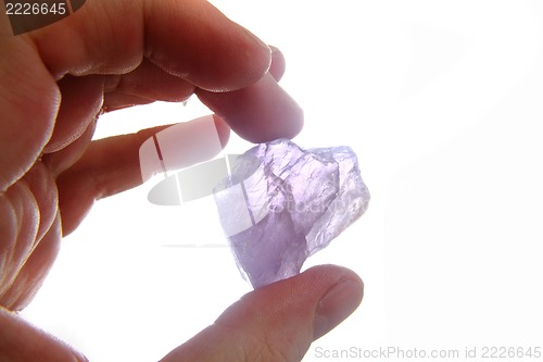 Image of violet amethyst in the human hand