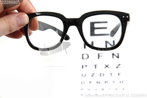 Image of eye test chart and black glasses