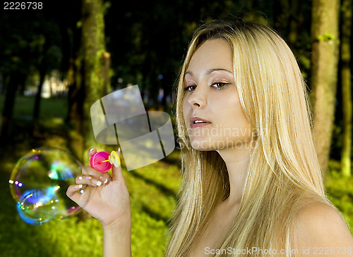 Image of blonde blowing soap bubbles