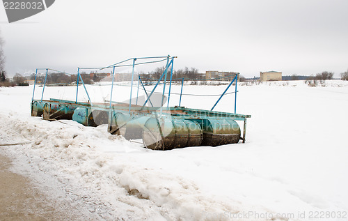 Image of quay dock old steel barrel snow lake shore winter 