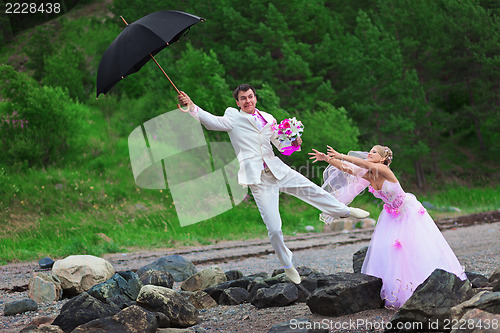 Image of Groom with umbrella and bride - wedding joke