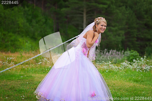 Image of Bride pulls a steel chain