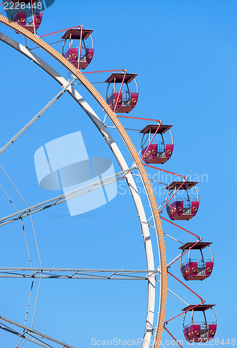 Image of Ferris wheel with red cabins