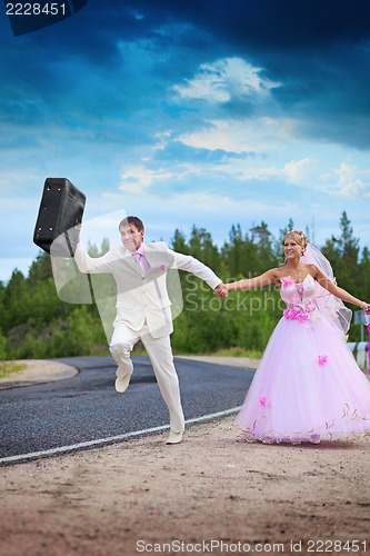 Image of Groom with suitcase seeks for a honeymoon