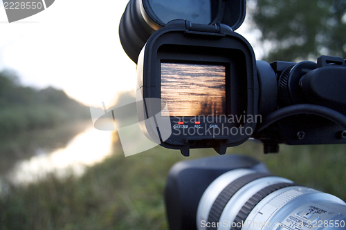 Image of A videocamera filming river