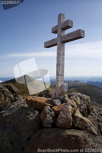 Image of mountain cross with bit mountains in the background