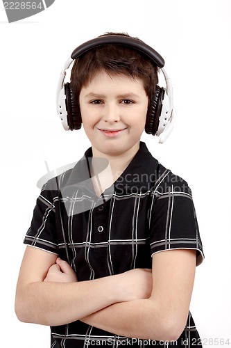 Image of Portrait of a happy smiling young boy listening to music on headphones