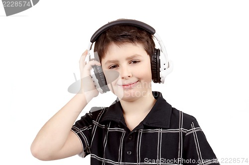 Image of Portrait of a happy smiling young boy listening to music on headphones