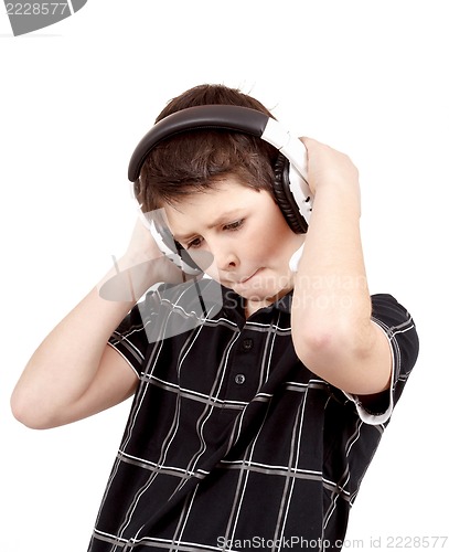 Image of Portrait of a happy young boy listening to music on headphones