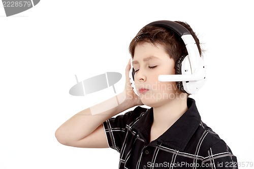 Image of Portrait of a happy young boy listening to music on headphones
