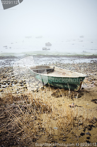 Image of Old fishing boat at coast foggy in the morning
