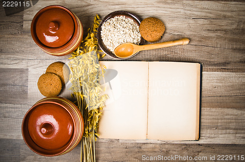 Image of Oatmeal cookies and an old recipe book on the kitchen table 