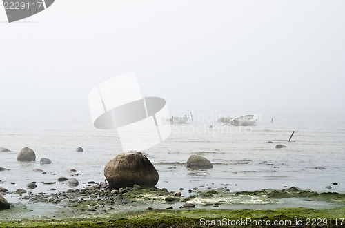 Image of Old fishing boat at coast foggy in the morning