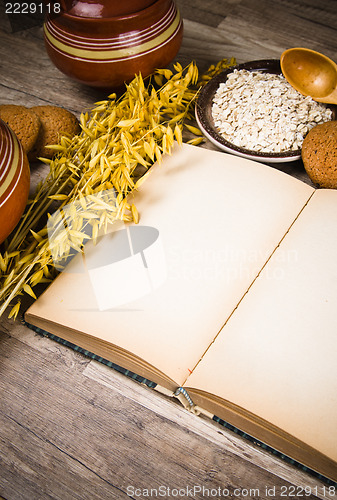 Image of Oatmeal cookies and an old recipe book on the kitchen table 