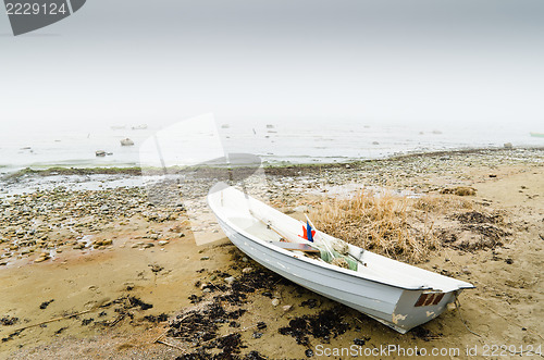 Image of Old fishing boat at coast foggy in the morning