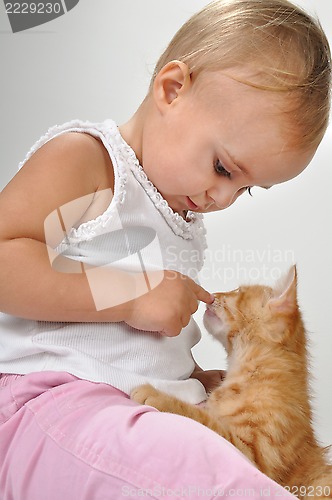 Image of toddler child plays with a cat