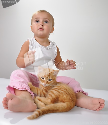 Image of toddler child plays with a cat