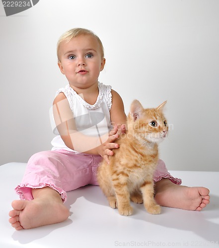 Image of toddler child plays with a cat