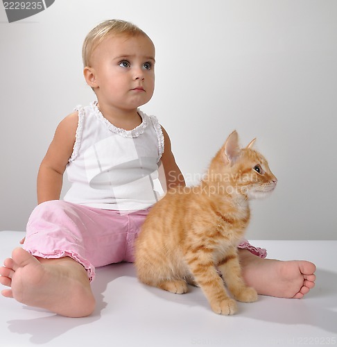 Image of toddler child plays with a cat