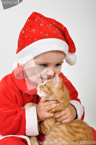 Image of Christmas toddler child plays with a cat