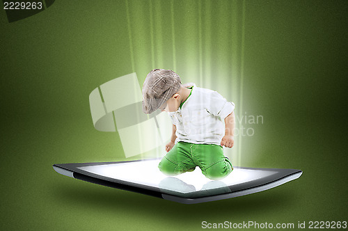 Image of Little boy on a tablet with beams of data