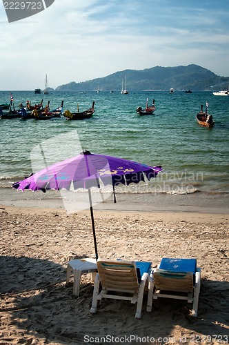 Image of Two chairs and umbrella on the beach