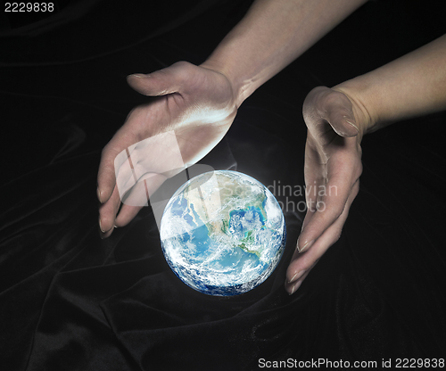 Image of crystal globe and hands