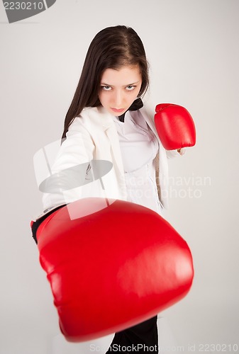 Image of young businesswoman in boxing gloves