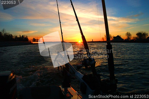 Image of fishing poles in boat on water