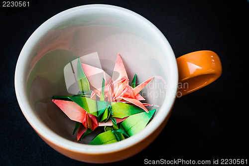 Image of Mug cup of paper birds on dark background