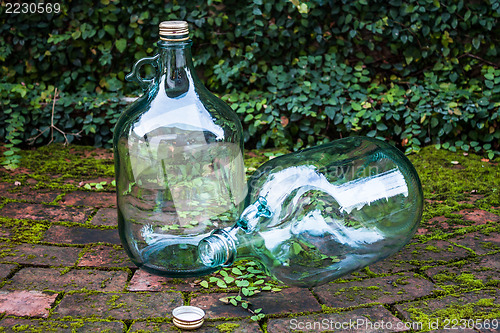 Image of Recycle big glass wine on garden brick floor